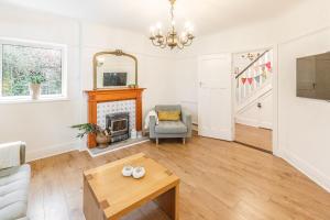 a living room with a fireplace and a chair at Host & Stay - Combpyne in Compton