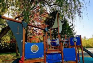 a playground with blue and wooden equipment in a park at SDG Családi Hotel és Konferencia Központ in Balatonszárszó