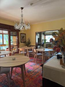 a dining room with tables and chairs and a chandelier at Casa do Ribeirinho in Amarante