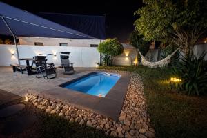 a backyard with a swimming pool and a table at 6 On Santorini in Langebaan