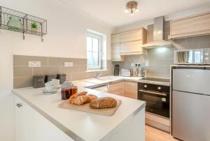 a kitchen with a counter with croissants and bread on it at 2 Bed in Woolacombe oc-beache in Woolacombe