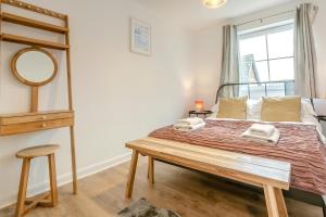 a bedroom with a bed with a mirror and a table at 2 Bed in Woolacombe oc-beache in Woolacombe
