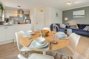 a dining room table with white chairs and a blue couch at 2 Bed in Woolacombe oc-beache in Woolacombe +7 photos