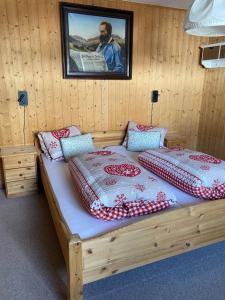 two beds in a wooden room with a picture on the wall at Zur Stilli Davos Dorf in Davos