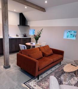 a living room with a brown couch and a table at Boerderij de Voorste Eng in Otterlo