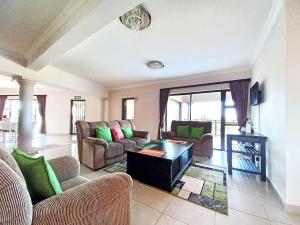 a living room with couches and a coffee table at Tuscany By The Sea in Port Edward