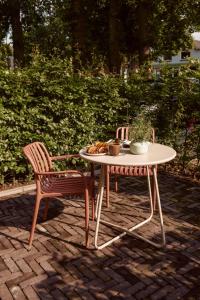 a table and two chairs on a brick patio at Boerderij de Voorste Eng in Otterlo