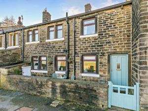 a brick house with a blue door and windows at 3 Bed in Holmfirth oc-91797 in Holmfirth