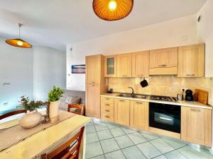 a kitchen with wooden cabinets and a sink and a table at Casa Appia - Authentic Beachfront House with Sea- View Garden in Santa Maria al Bagno - Marea Stays Collection in Nardò +13 photos
