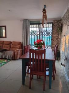 a dining room with a table and chairs and a couch at Mamela BNB in Elandsfontein