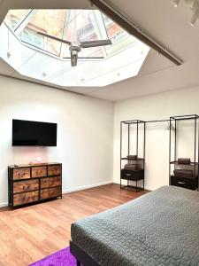 a bedroom with a bed and a flat screen tv at Der Stader Turmblick in Stade