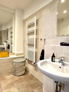 a white bathroom with a sink and a mirror at Der Stader Turmblick in Stade +11 photos