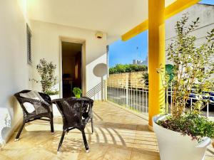 a balcony with two chairs and plants at Casa Appia - Authentic Beachfront House with Sea- View Garden in Santa Maria al Bagno - Marea Stays Collection in Nardò