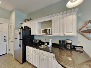 a kitchen with white cabinets and a black refrigerator at Inn at Seacrest #203 - 30A Get-A-Way in Rosemary Beach +11 photos