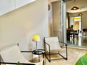 a living room with two chairs and a table at Casa Appia - Authentic Beachfront House with Sea- View Garden in Santa Maria al Bagno - Marea Stays Collection in Nardò