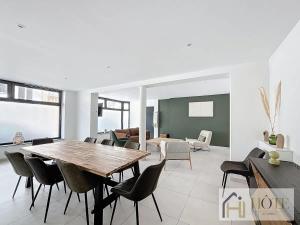 a dining room with a wooden table and chairs at L'Instant Elégant - Plage à 100m in Bray-Dunes