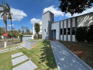 a white building with a stop sign in front of it at Astor Suítes - Unicamp in Campinas