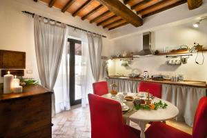 a kitchen with a table and red chairs in a kitchen at Bosco Ai Marzi - 2 Apartments with shared pool in Poggibonsi