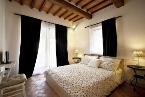 a bedroom with a large bed with black curtains at Bosco Ai Marzi - 2 Apartments with shared pool in Poggibonsi