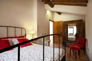 a bedroom with a bed and a red chair at Bosco Ai Marzi - 2 Apartments with shared pool in Poggibonsi +29 photos