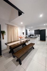 a kitchen with a wooden table and a bench at 6 On Santorini in Langebaan