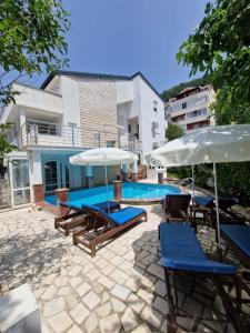a swimming pool with lounge chairs and umbrellas at Adriatic Villa Matea in Budva