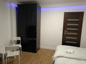 a bedroom with a bed and a table and chairs at Via Room in Raszyn
