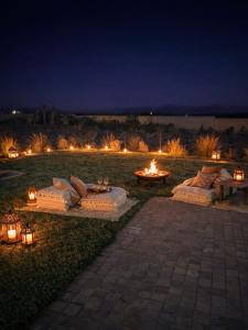 a fire pit with pillows and candles in a field at night at Palais Victoria in El Aïn