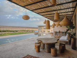 a patio with a table and a swimming pool at Palais Victoria in El Aïn