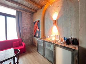a living room with a red couch and a counter at Emmeloft I Orange Moon - Vibrant Modern Luxury Loft Milan in Milan
