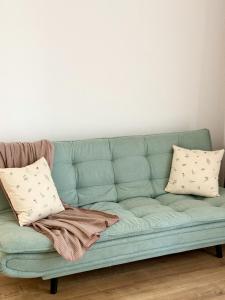 a green couch with two pillows on it at Forestis Thermalis in Baile Felix