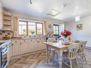 a large kitchen with a wooden table and a dining room at 2 Bed in Holsworthy oc-00813 in Pyworthy