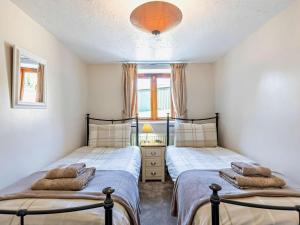two twin beds in a bedroom with a window at 2 Bed in Holsworthy oc-00813 in Pyworthy