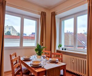 a dining room with a table and two windows at City Center Apartments - Moderna Brno Římské náměstí IV in Brno