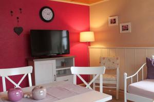 a living room with a tv and a table and chairs at FeWo Alte Post in Oberdigisheim