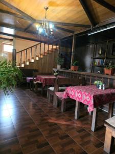 a restaurant with tables and benches and a staircase at Gosh hotel in Gosh