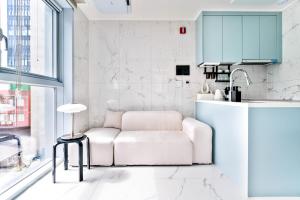 a white living room with a couch and a table at Balance Seoul Stay in Seoul