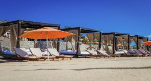 a row of chairs and umbrellas on a beach at Pueblo Bonito Sunset Beach Owners Studio Suite, REQUEST DATES see by Clay & Lisa in Cabo San Lucas