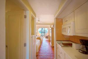 a kitchen with a room with a bed and a microwave at Owners Studio Suite, REQUEST DATES- see by Clay & Lisa in Cabo San Lucas