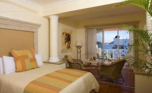 a hotel room with a bed and a balcony at Owners Studio Suite, REQUEST DATES- see by Clay & Lisa in Cabo San Lucas
