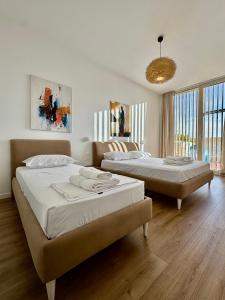 a bedroom with two beds and a chandelier at Veranda Apartment, Green Coast in Palasë