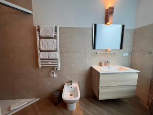 a bathroom with a sink and a toilet and a tv at Emmeloft I Orange Moon - Vibrant Modern Luxury Loft Milan in Milan +8 photos