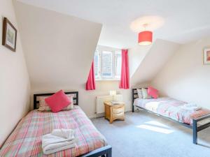 two beds in a attic bedroom with red curtains at 5 Bed in Wareham oc-dc032 in West Lulworth