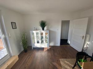 a living room with a cabinet with a plant on it at Ferienwohnung Pauline in Plön +15 photos