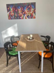 a dining room table with chairs and a painting on the wall at Ferienwohnung Pauline in Plön