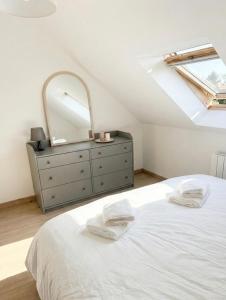 a bedroom with a bed and a dresser with a mirror at La perle du Centre à Cancale in Cancale