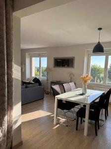 a living room with a table and chairs and a couch at La perle du Centre à Cancale in Cancale