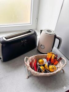 a basket filled with food next to a toaster at La perle du Centre à Cancale in Cancale +14 photos