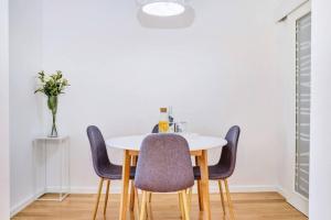 a dining room with a white table and chairs at Beautiful new apartment Blaz in Mali Lošinj