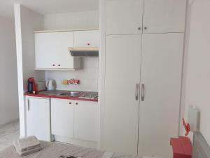 a kitchen with white cabinets and a sink at Ponderosa Holiday Studio 701 in Playa de las Americas